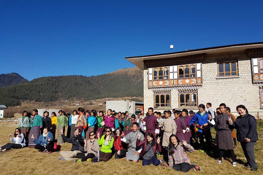 Tourist and guide posing in front of building gangtey trek