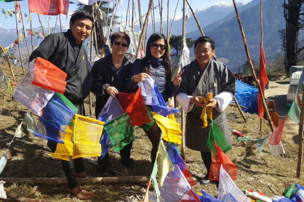 Guide and tourist near prayer flags trail laya trek